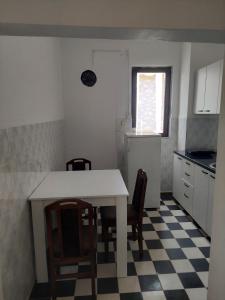 eine Küche mit einem weißen Tisch und Stühlen in einem Zimmer in der Unterkunft Comfort in Pirot