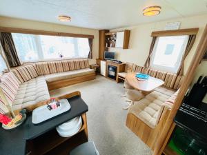 a living room with a couch and a table at 2 Bedroom Caravan NV16, Lower Hyde, Shanklin, Isle of Wight in Shanklin