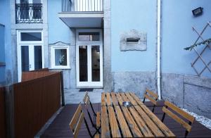un banco de madera sentado frente a un edificio azul en ChillHouse_Porto en Oporto