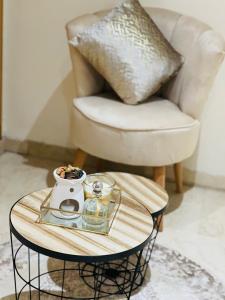 une table basse avec une tasse et une chaise dans l'établissement Superbe Appartement au coeur de Casablanca, à Casablanca