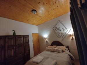 Schlafzimmer mit einem Bett mit Holzdecke in der Unterkunft Rikra Purmamarca in Purmamarca