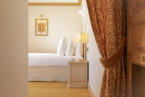 - une chambre avec un lit et une table avec une lampe dans l'établissement Airelles Château de la Messardière, à Saint-Tropez