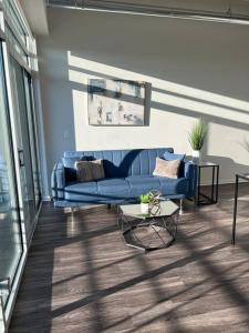 a living room with a blue couch and a table at Apt Downtown Detroit with VIEW in Detroit