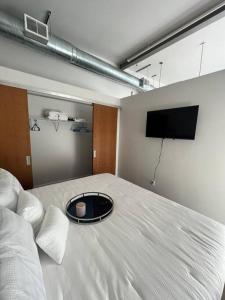 a bedroom with a large bed with a tv on the wall at Apt Downtown Detroit with VIEW in Detroit