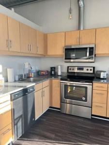a kitchen with stainless steel appliances and wooden cabinets at Apt Downtown Detroit with VIEW in Detroit