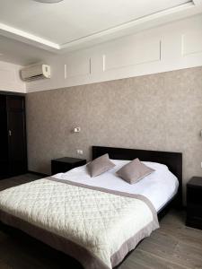 1 dormitorio con 1 cama grande con sábanas y almohadas blancas en Sun Lidia en Chernivtsi