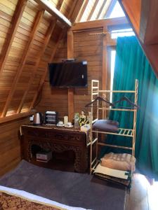Resort & Resto Talaga Sundayana في سوبانج: غرفة مع سرير بطابقين ومكتب مع تلفزيون