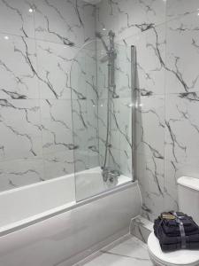 a bathroom with a shower and a toilet and a tub at Flitwick Luxury Apartment in Flitwick