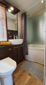 ein Badezimmer mit einem Waschbecken, einem WC und einer Badewanne in der Unterkunft Blue Water Breaks - Dawlish Warren in Dawlish