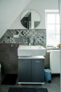 y baño con lavabo y espejo. en Designapartment im Herzen der Altstadt - 3BR - 7 Guests - fully equipped kitchen, en Limburg an der Lahn