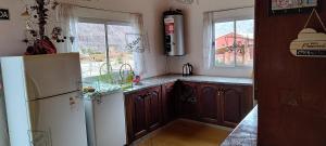 eine Küche mit einem weißen Kühlschrank und einer Spüle in der Unterkunft Rikra Purmamarca in Purmamarca + 22 Fotos
