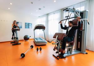 un uomo e una donna in una palestra con attrezzature sportive di Mercure Roma Piazza Bologna a Roma