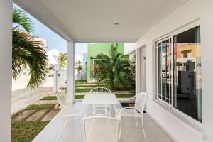 uma sala de jantar branca com uma mesa e cadeiras brancas em Casa MiAmore - Family Getaway em Cancún