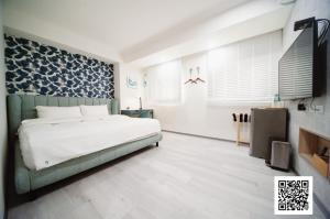 a bedroom with a white bed and a blue patterned wall at 虎尾小9窩-採自助式入住 in Huwei