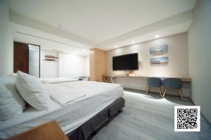 a bedroom with a large bed and a flat screen tv at 虎尾小9窩-採自助式入住 in Huwei
