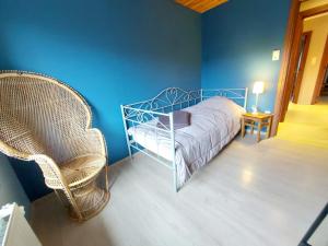een slaapkamer met een bed en 2 rieten stoelen bij Les Gîtes du Rancourt - Sous la Grange & Le Logis in Sainte-Ode