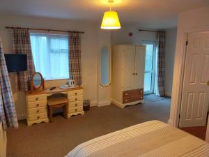 a bedroom with a bed and a desk and a mirror at The Green Dragon Inn in Redditch
