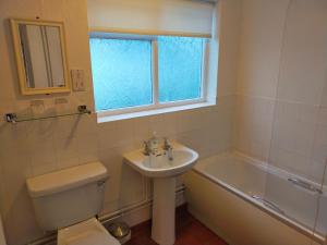 a bathroom with a sink and a toilet and a window at The Green Dragon Inn in Redditch