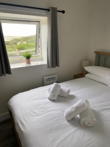 two white beds in a room with a window at Dondie's House, Kilchoan in Kilchoan