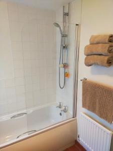 a bathroom with a tub and a shower with towels at The Green Dragon Inn in Redditch