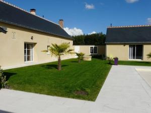 a house with a yard with palm trees in it at Maison indépendante et privative 52m2 au calme in Cléré-les-Pins