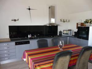 a kitchen with a table with a striped table cloth at Maison indépendante et privative 52m2 au calme in Cléré-les-Pins