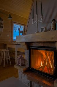 a fireplace in a log cabin with a window at Alemiło - uroczy dom z balią i widokiem na Babią Górę in Zawoja