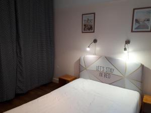 - une chambre avec un lit muni d'un panneau dans l'établissement LA PLAGE, à Berck-sur-Mer