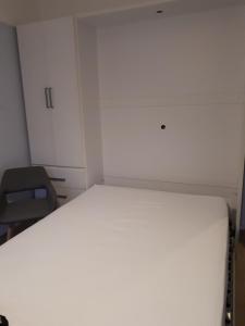 Cette petite chambre comprend un lit et une chaise. dans l'établissement LA PLAGE, à Berck-sur-Mer