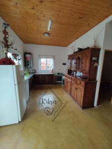 eine Küche mit einem weißen Kühlschrank und einer Holzdecke in der Unterkunft Rikra Purmamarca in Purmamarca