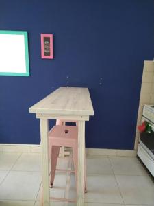 a wooden table and stool in a kitchen with a blue wall at Luminoso monoambiente con cochera propia dentro del edificio in La Plata