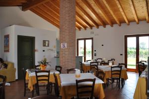 a dining room with tables and chairs and windows at Agriturismo ai Ciliegi in Bardolino