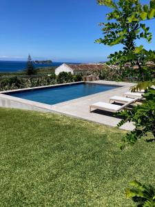 una piscina en un patio con césped verde en Guava Azores II, en Ribeira das Tainhas