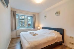 ein Schlafzimmer mit einem Bett mit zwei Handtüchern darauf in der Unterkunft Lichtrijk appartement in hartje Knokke vlak bij shoppingstraat & strand in Knokke-Heist