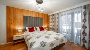 1 dormitorio con cama grande y ventana grande en Apartamenty Sun & Snow Resorts F Białka Tatrzańska z sauną, en Białka Tatrzanska
