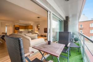 ein Wohnzimmer mit einem Sofa und einem Tisch in der Unterkunft Lichtrijk appartement in hartje Knokke vlak bij shoppingstraat & strand in Knokke-Heist
