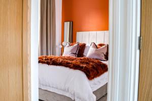 een slaapkamer met een bed met een oranje muur bij Liberty Redcar in Redcar