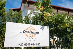 a sign on a fence in front of a house at Anastasia Mare Studios in Pefkochori