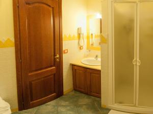 uma casa de banho com um lavatório e uma porta de madeira em Guest House Dolce Vita em Cala Gonone