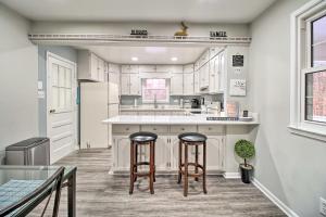 a kitchen with white cabinets and two bar stools at Cozy Woodbridge Home with Fire Pit and Deck in Woodbridge