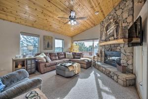 a living room with a couch and a stone fireplace at Woodland Park Home with Stunning Mountain Views in Woodland Park
