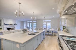 a large kitchen with white cabinets and a large island at Shelter Island Retreat with Outdoor Pool! in Shelter Island