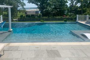 una piscina de agua azul en un patio en Shelter Island Retreat with Outdoor Pool! en Shelter Island