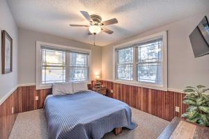 una camera con letto e ventilatore a soffitto di Spacious Home with Deck on Lake Chetek! a Chetek