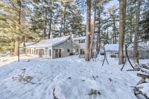 a house in the woods with snow on the ground at Spacious Home with Deck on Lake Chetek! in Chetek