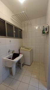 y baño con lavabo y aseo. en Apartamento Aconchegante Familiar - 3 Quartos - Guarapari - Centro, en Guarapari