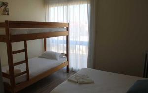 una camera da letto con due letti a castello e una finestra di Hotel de la Plage - Barcares a Le Barcarès