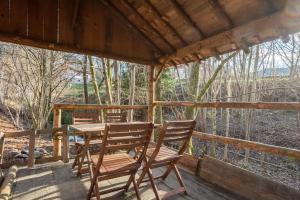 a table and chairs on the porch of a cabin at La Bergerie Des Amis in Ventron