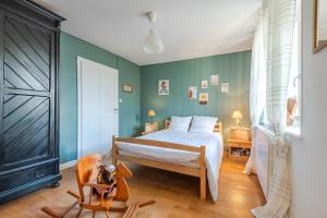 a bedroom with a bed and a dog in a chair at La Bergerie Des Amis in Ventron