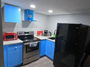 a kitchen with blue cabinets and a black refrigerator at Gorgeous Basement Apartment in Calgary